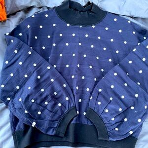 XL blue polka dot sweater with black cuffing and bell sleeves.